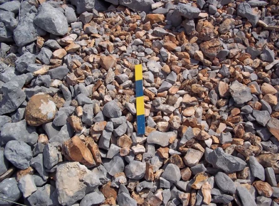 Σωρός από πέτρες, στον οποίον ξεχωρίζουν τα εργαλεία από πυροτόλιθο με πορτοκαλί χρώμα.
