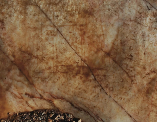 Η πέτρα που βρέθηκε με το σχέδιο του ναού και την επιγραφή.