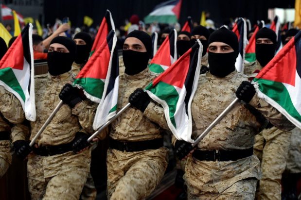 Μαχητές της Χεζμπολάχ κρατούν σημαίες της Παλαιστίνης