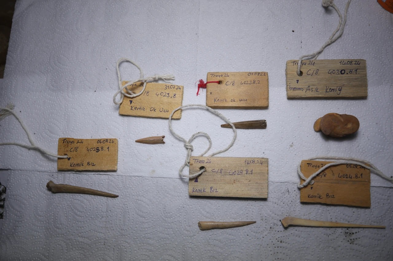 Πρόσφατες ανακαλύψεις στην αρχαία πόλη της Τροίας, έχουν φέρει στο φως μια αιχμή βέλους ηλικίας 3.500 ετών, ένα οστό από δάχτυλο και ένα αιχμηρό εργαλείο φτιαγμένο από οστά, το οποίο χρησιμοποιούταν για τη διάτρηση υφασμάτων και δέρματος. Φωτογραφία: AA