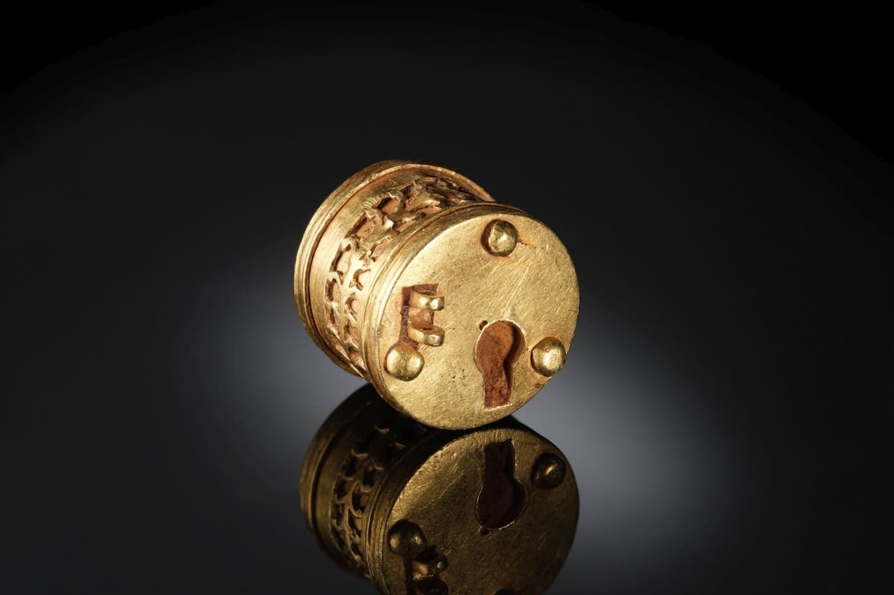 Η χρυσή και σιδερένια κλειδαριά έχει μέγεθος1.1 cm x 1.2 cm.