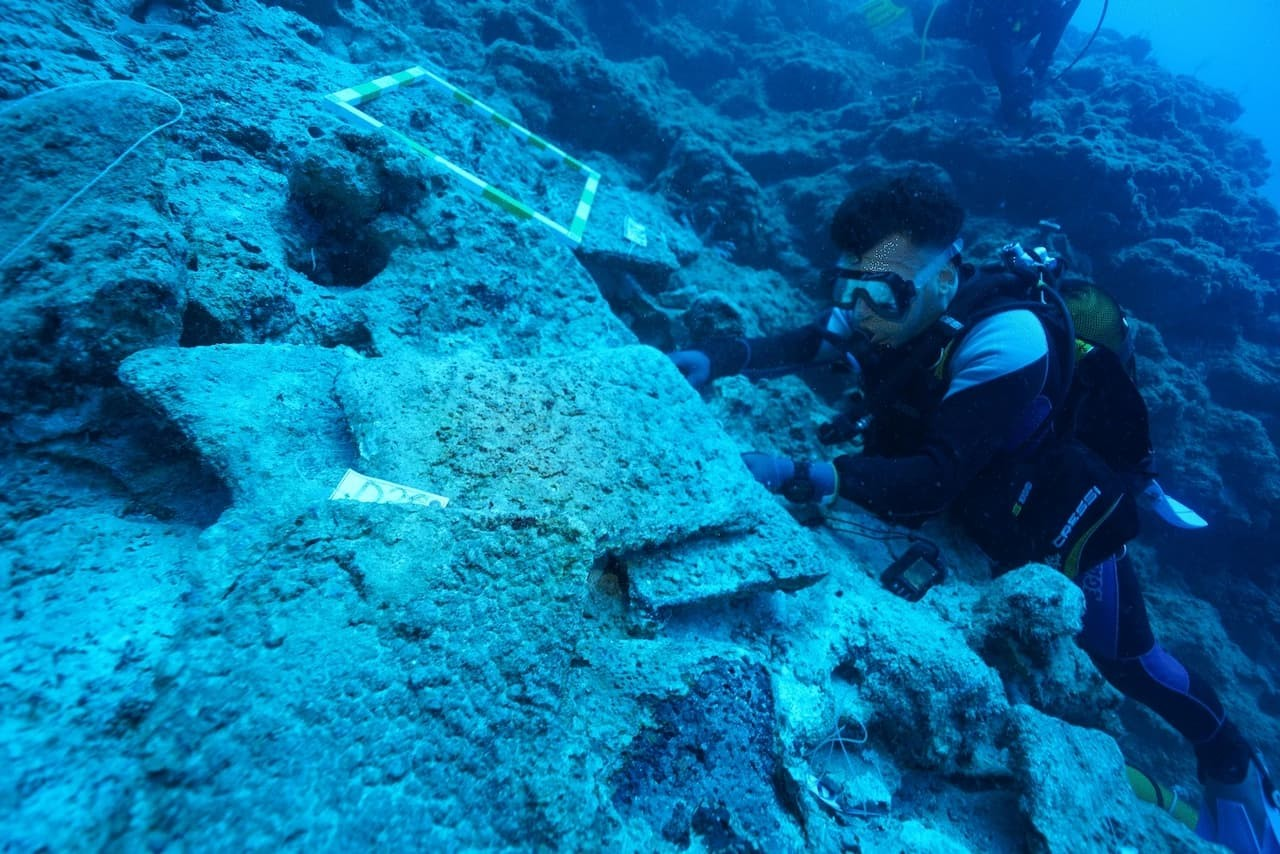 Αρχαιολόγοι μελετούν τα χάλκινα πλινθώματα που κουβαλούσε το πλοίο. Φωτογραφία: Hakan Öniz