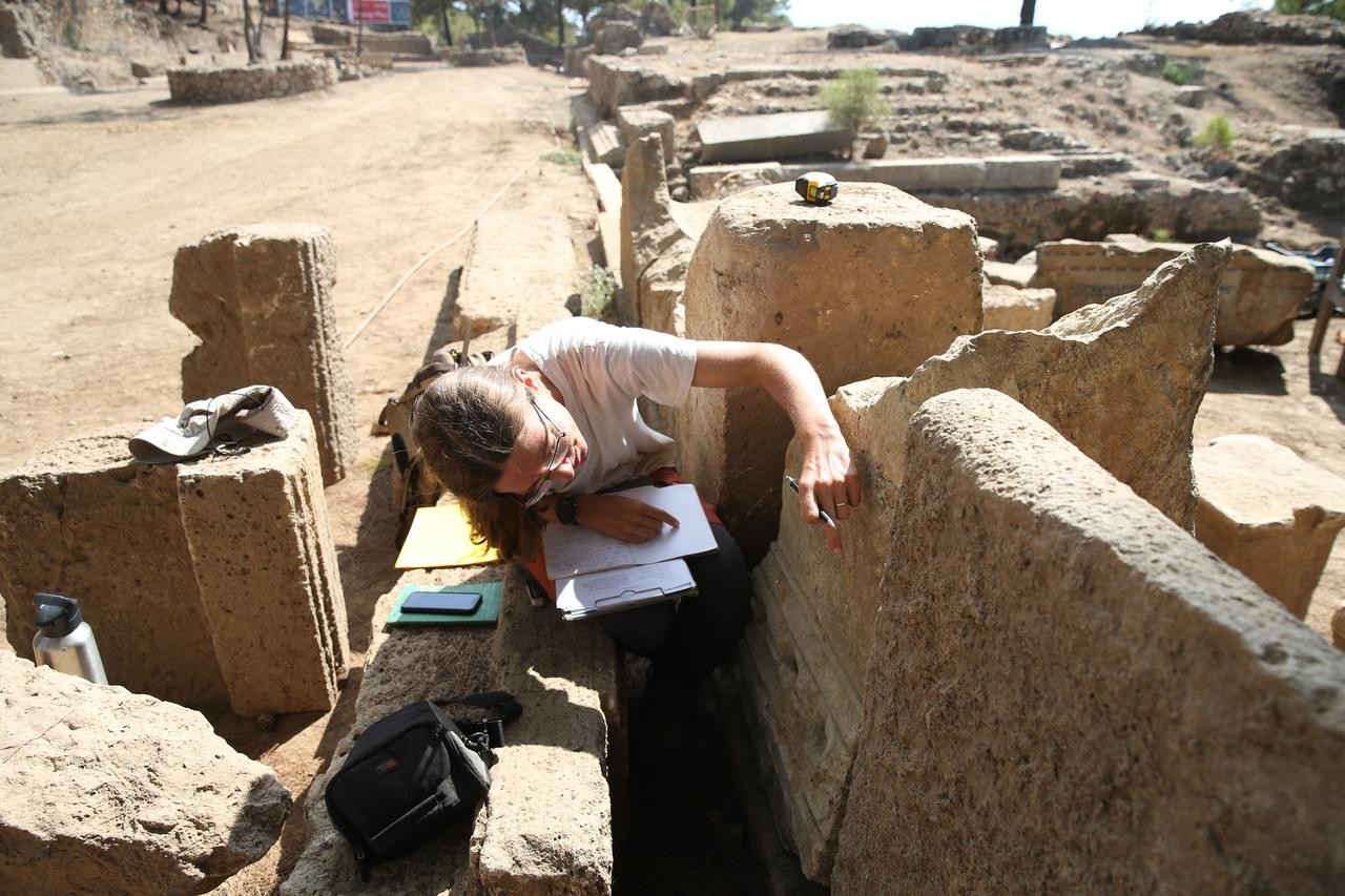 Αρχαιολόγος μελετά τα λίθινα τμήματα στη διάρκεια των ανασκαφών στο στάδιο της Σύεδρας στην Αττάλεια. Φωτογραφία: ΑΑ