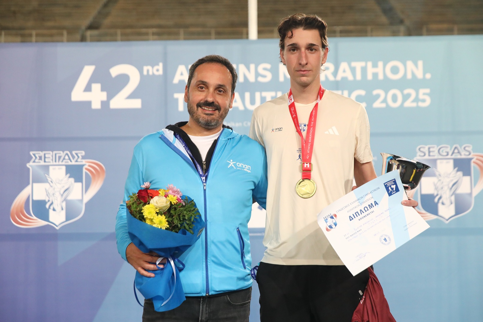 Ο Chief Online Officer του ΟΠΑΠ, Γιάννης Πανόπουλος, με τον νικητή των 5χλμ Universities Night Run ΟΠΑΠ, Κωνσταντίνο Βεδουρά