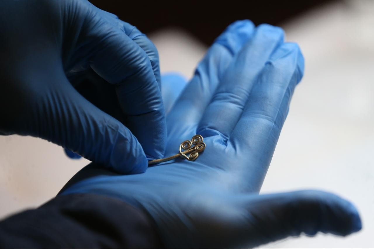 Ο καθηγητής Rustem Aslan εξετάζει νεοανακαλυφθέντα τεχνουργήματα της Εποχής του Χαλκού υπό το εργαστηριακό φως στο Μουσείο Τροίας, στα Δαρδανέλια (Canakkale), Τουρκία, στις 17 Νοεμβρίου 2025. Φωτογραφία: ΑΑ