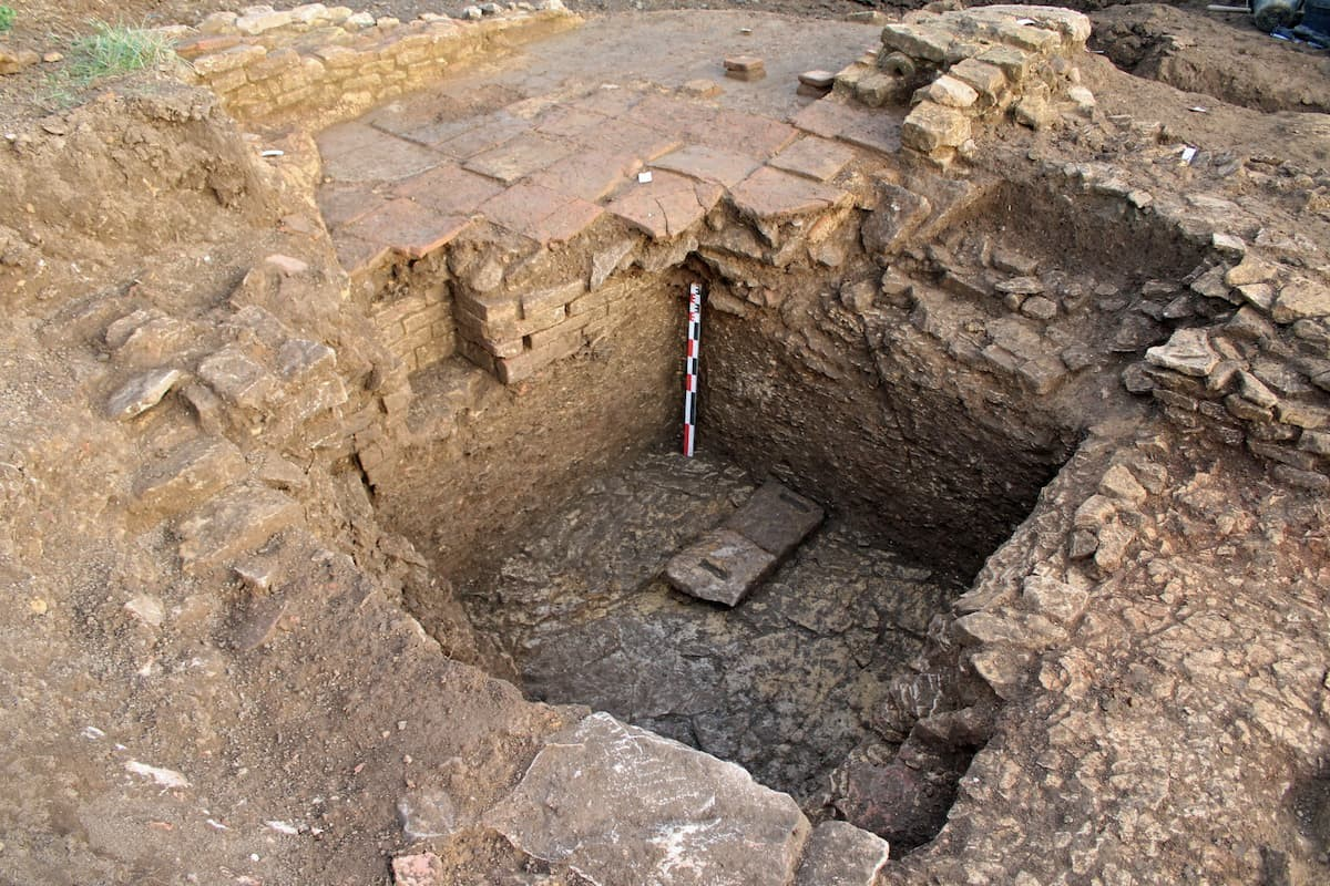 Το δάπεδο ενός υπόκαυστου (συστήματος θέρμανσης δαπέδου), κατασκευασμένο από επαναχρησιμοποιημένα κεραμίδια και τοποθετημένο πάνω από ένα εγκαταλελειμμένο κελάρι, απεικονίζει τις αναδιαμορφώσεις της γειτονιάς κατά την ύστερη αρχαιότητα. Φωτογραφία: Simon Ritz, Inrap 