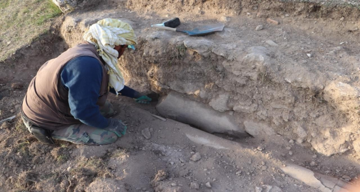 Ένας αρχαιολόγος αποκαλύπτει τον κορμό ενός αγάλματος της ρωμαϊκής εποχής ενσωματωμένο στο τείχος του σταδίου κατά τη διάρκεια συνεχιζόμενων ανασκαφών στην αρχαία πόλη Βλαύνδο στην Ουσάκ της δυτικής Τουρκίας, 25 Νοεμβρίου 2025. Φωτογραφία μέσω Ανασκαφών Βλαύνδου