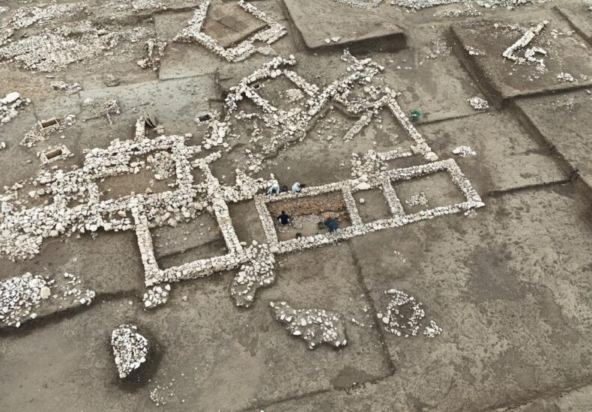 Οι αρχαιολόγοι εξετάζουν τον κατεστραμμένο τοίχο από λάσπη μέσα στο ορθογώνιο κτίριο που ανακαλύφθηκε στο Çayönü. Ο προσανατολισμός του πεσμένου τμήματος υποδεικνύει καταστροφή που προκλήθηκε από σεισμική δραστηριότητα. | Φωτογραφία: IHA