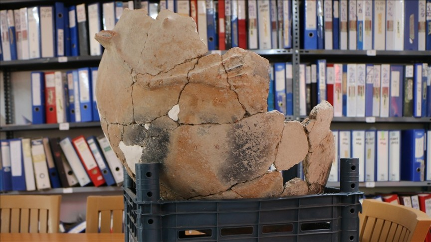 Πλάγια όψη του τάφου-πίθου της Πρώιμης Εποχής του Χαλκού που ανασκάφηκε στην Κιουλούμπα (Küllüoba), που δείχνει εργασίες αποκατάστασης στην σπασμένη επιφάνεια του αγγείου. Φωτογραφία: Zehra Ongan/AA