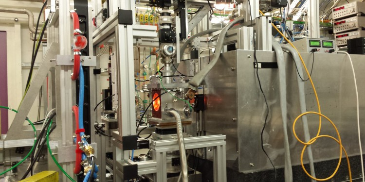 Η πειραματική διάταξη, η οποία περιλαμβάνει έναν θάλαμο κενού όπου στεγάζεται μια κυψέλη διαμαντένιου άκμονα υψηλής θερμοκρασίας. Το πορτοκαλί χρώμα της κυψέλης προέρχεται από το φως που εκπέμπει σε υψηλές θερμοκρασίες., Φωτογραφία: Carmen Sánchez-Valle 