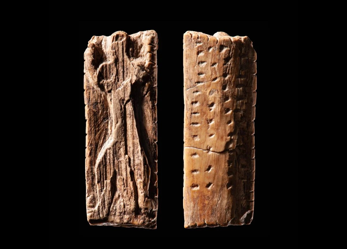 Το Λατρευτικό ειδώλιο από το Σπήλαιο Geißenklösterle, ηλικίας περίπου 40.000 ετών, αποτελείται από μια μικρή πλάκα από ελεφαντόδοντο που φέρει μια ανθρωπόμορφη μορφή και πολλαπλές ακολουθίες εγκοπών και κουκκίδων. Η εφαρμογή αυτών των σημαδιών υποδηλώνει ένα σύστημα σημειογραφίας, κυρίως στις σειρές κουκκίδων στο πίσω μέρος της πλάκας. (Φωτογραφία: Landesmuseum Württemberg / Hendrik Zwietasch, CC BY 4.0)