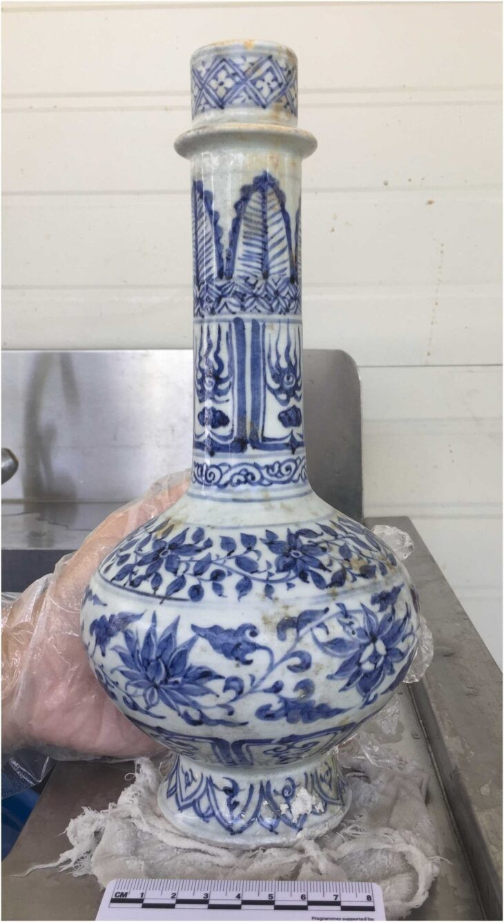 Μια άθικτη φιάλη με προεξέχοντα λαιμό (φλάντζα), κατά τη διάρκεια της διαδικασίας καθαρισμού.Πηγή: Flecker, 2025, Journal of International Ceramic Studies Στην ανατολική είσοδο των Στενών της Σιγκαπούρης, δύτες που αναέσυραν θραύσματα από τον βυθό δεν περίμεναν ότι θα αμφισβητούσαν ένα εδραιωμένο ιστορικό αφήγημα. Κι όμως, σχεδόν τέσσερα χρόνια ανασκαφών κατάφεραν ακριβώς αυτό. Η ανακάλυψη και η ανάλυση του Ναυαγίου του Temasek, ενός ναυαγίου των μέσων του 14ου αιώνα που βρέθηκε στα ύδατα της Σιγκαπούρης, αναδιαμορφώνει τον τρόπο με τον οποίο οι ιστορικοί αντιλαμβάνονται το προ-αποικιακό παρελθόν της χώρας. Αντί για ένα ήσυχο αλιευτικό φυλάκιο, τα αρχαιολογικά στοιχεία δείχνουν τώρα ένα εξελιγμένο και καλά διασυνδεδεμένο ναυτιλιακό κέντρο, βαθιά ενσωματωμένο στα εμπορικά δίκτυα της Ασίας κατά την εποχή της δυναστείας Γιουάν.