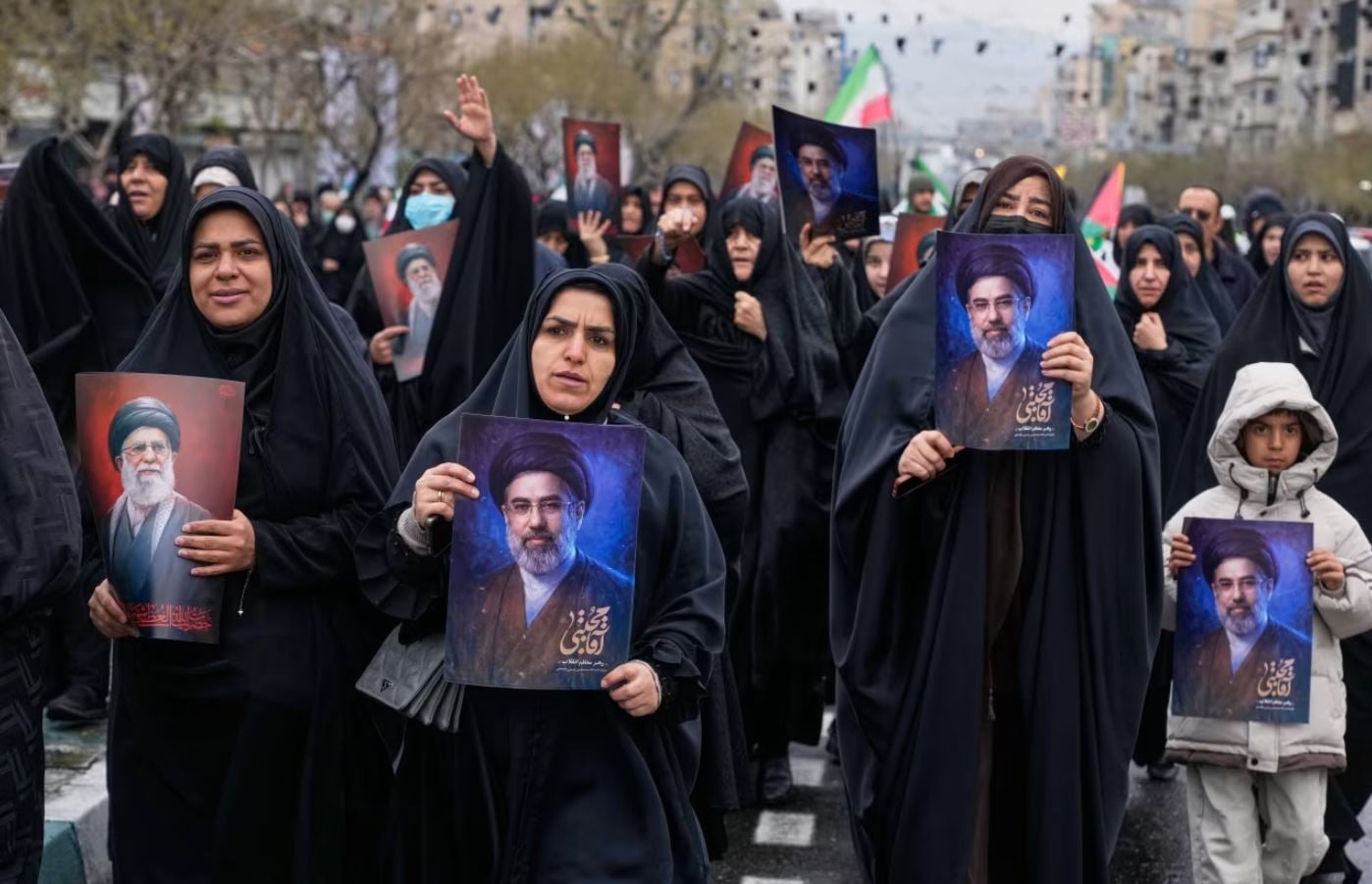Διαδηλωτές παρελαύνουν κρατώντας φωτογραφίες του Ανώτατου Ηγέτη του Ιράν, Αγιατολάχ Μοτζτάμπα Χαμενεΐ, και του εκλιπόντος πατέρα του, κατά τη διάρκεια της ετήσιας Ημέρας Αλ Κουντς στην Τεχεράνη, την Παρασκευή. Βαχίντ Σαλέμι/AP
