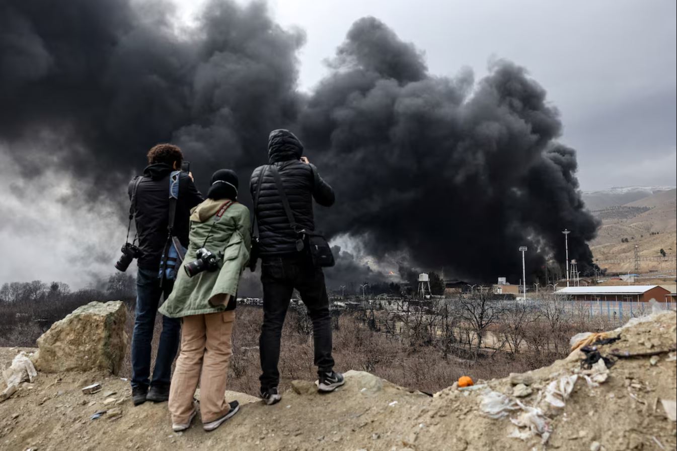 Άνθρωποι καταγράφουν καπνό να ανεβαίνει μετά από μια αναφερόμενη επίθεση στις δεξαμενές καυσίμων Shahran, εν μέσω της σύγκρουσης ΗΠΑ-Ισραήλ με το Ιράν, στην Τεχεράνη,