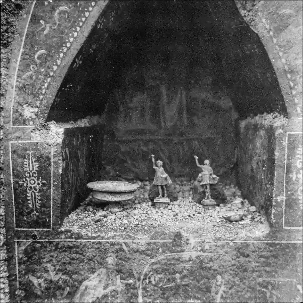 Οικιακό ιερό στην «Οικία του Λαράριου του Σάρνο» (I.14.7) με αγαλματίδια των Λαρήτων (Lares), έναν λύχνο και ένα θυμιατήριο. Πηγή: Πομπηία, Φωτογραφικό Αρχείο αρ. ευρετηρίου D964