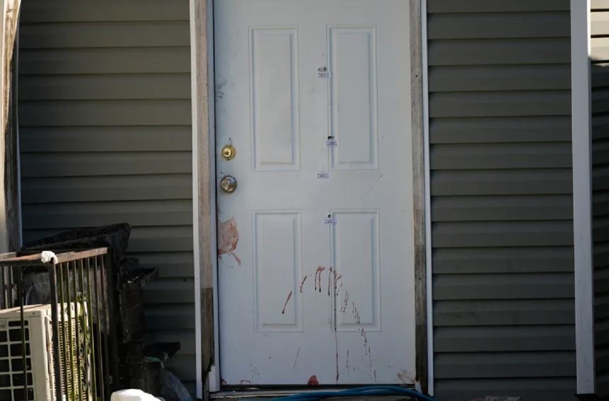 Μια πόρτα που φαίνεται να είναι λερωμένη με αίμα και φέρει σημάνσεις αποδεικτικών στοιχείων παραμένει κλειστή έξω από το σημείο μαζικών πυροβολισμών, την Κυριακή 19 Απριλίου, στη Σρίβπορτ της Λουιζιάνα. Gerald Herbert/AP