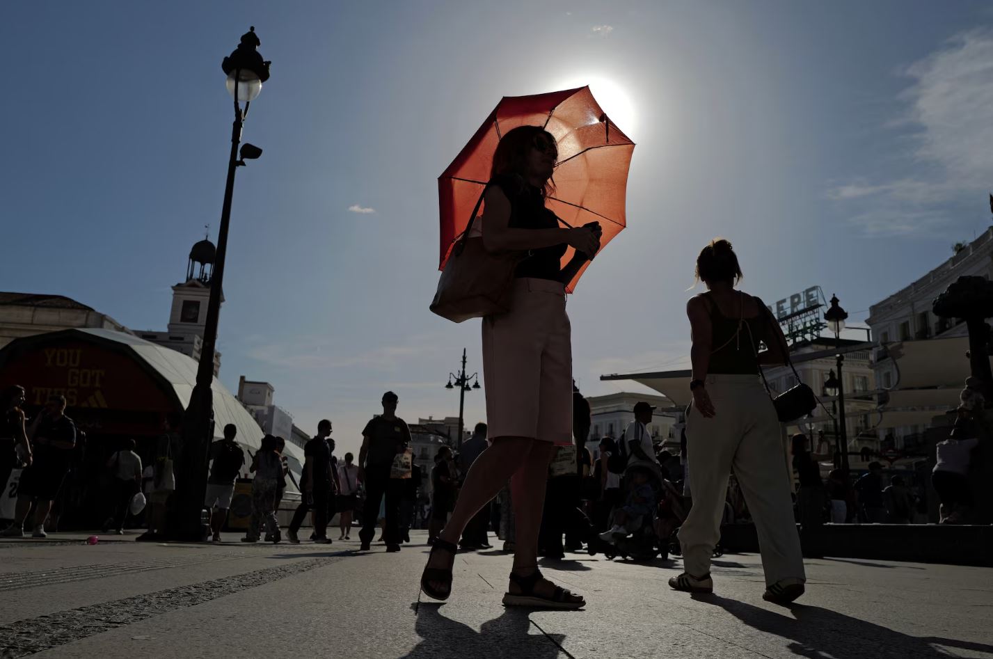 Μια γυναίκα κρατά ομπρέλα στην Πλατεία Πουέρτα ντελ Σολ στη Μαδρίτη, κατά τη διάρκεια του κύματος καύσωνα που πλήττει την Ισπανία. REUTERS/Kacper Pempel