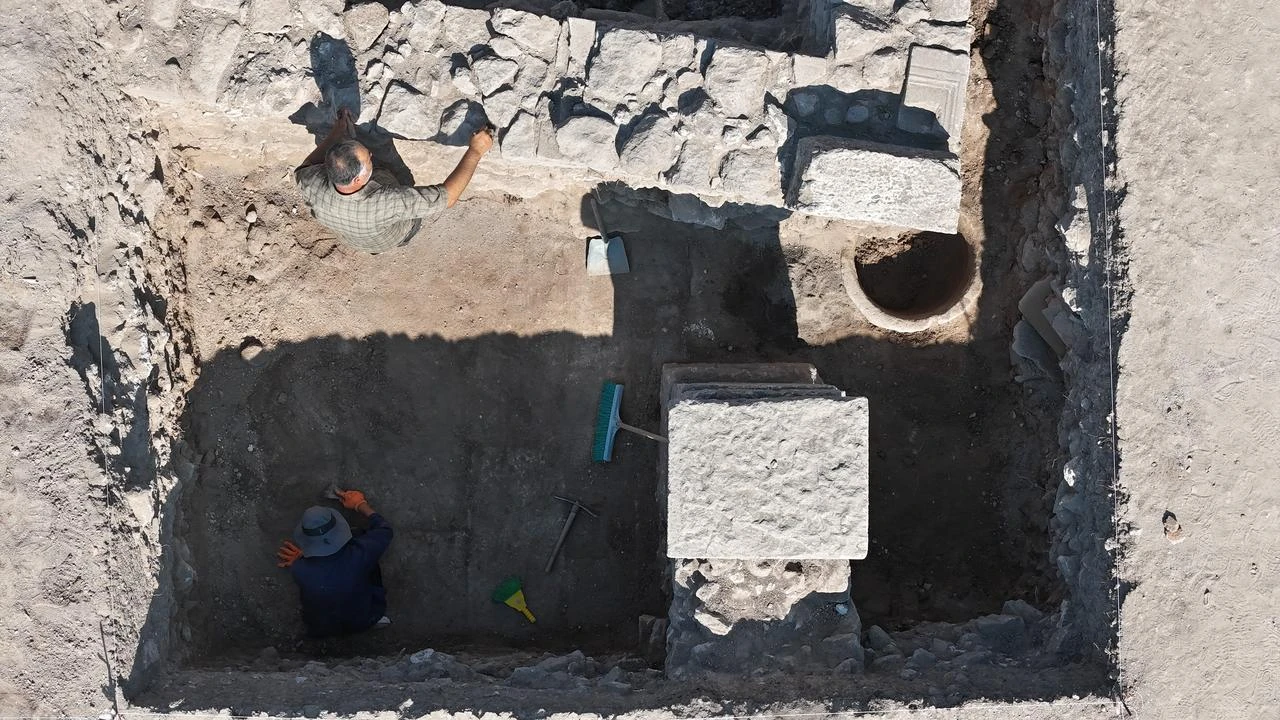 Μια πανοραμική λήψη από ψηλά δείχνει αρχαιολόγους να εργάζονται δίπλα σε έναν αρχαίο αποθηκευτικό πίθο στην περιοχή των Δυτικών Λουτρών του Ιερού του Απόλλωνα Σμινθέα στα Δαρδανέλια (Τσανάκκαλε) της Τουρκίας, Ιούλιος 2026. (Φωτογραφία: IHA) 