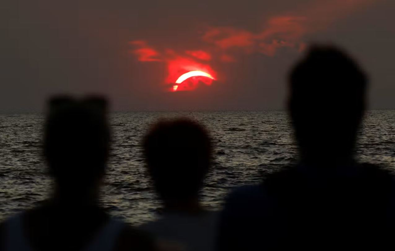 Κόσμος παρακολουθεί την έκλειψη Ηλίου από το Πιράν της Σλοβενίας. Φωτογραφία: Reuters / Borut Zivulovic