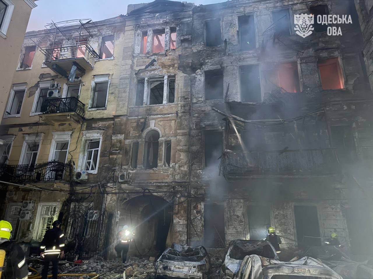Εκτεταμένες ζημιές σε κτίριο κατοικιών στην Οδησσό μετά τη ρωσική επίθεση, ενώ πυροσβέστες επιχειρούν στο σημείο. Φωτογραφία: Στρατιωτική Διοίκηση Περιφέρειας Οδησσού (Odesa OVA)