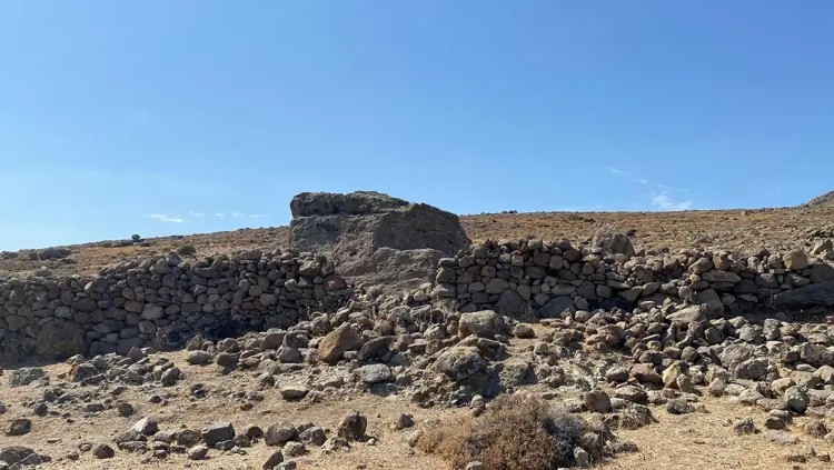 Το λαξευμένο στον βράχο ταφικό μνημείο βρίσκεται μέσα στο ξηρό τοπίο με τους ξερολιθικούς τοίχους στη νότια πλευρά της Ίμβρου. Φωτογραφία: Ναζίφ Τζεμχάν Σεν 