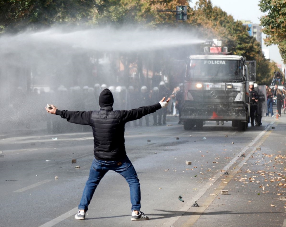 Αστυνομικές δυνάμεις χρησιμοποιούν εκτοξευτήρες νερού και δακρυγόνα εναντίον διαδηλωτών στα Τίρανα, την Πέμπτη (15/10), καθώς κλιμακώνονται οι αντικυβερνητικές κινητοποιήσεις στην αλβανική πρωτεύουσα. (Φωτογραφία: Malton Dibra/EPA)