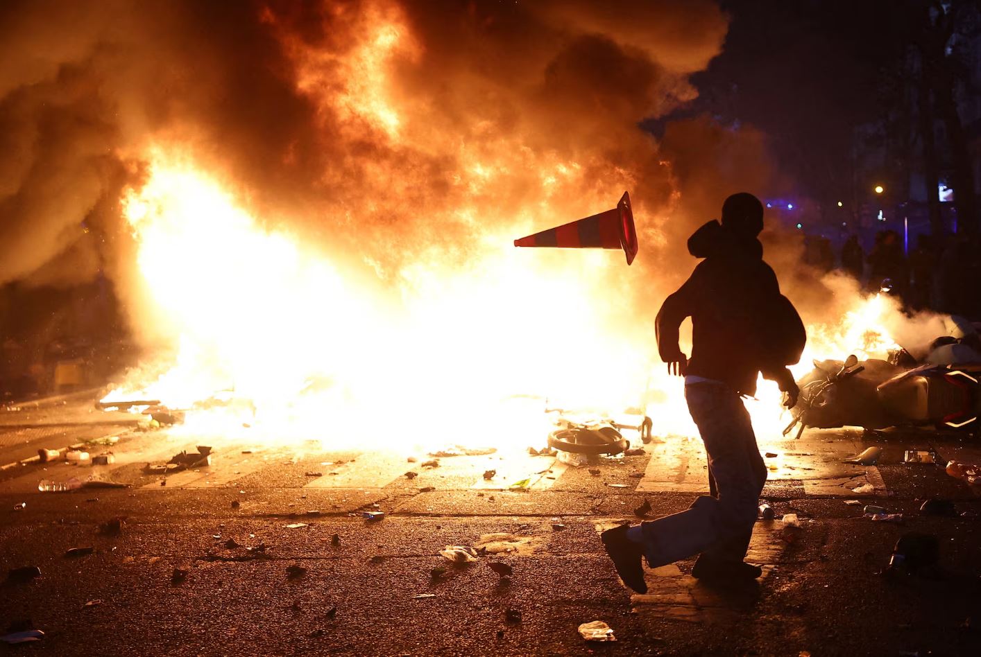 Διαδηλωτές κάθονται σε καρέκλες που έχουν μεταφέρει από κατάστημα το οποίο υπέστη βανδαλισμούς, αποκλείοντας δρόμο στο Παρίσι, κατά τη διάρκεια επεισοδίων στις 17 Οκτωβρίου 2026. Φωτογραφία: Abdul Saboor/Reuters