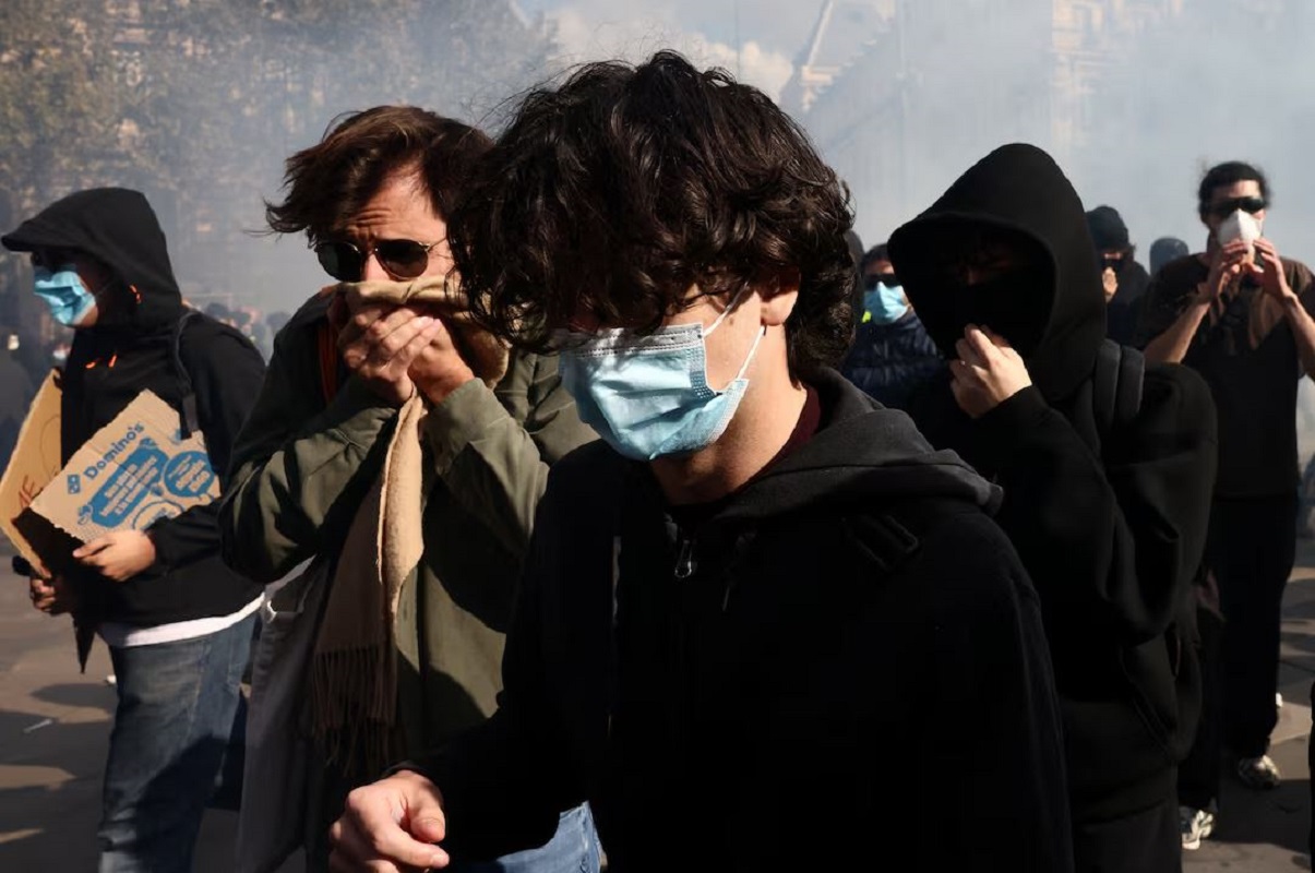 Διαδηλωτής με καλυμμένο το πρόσωπο προσπαθεί να απομακρυνθεί από την Πλατεία Δημοκρατίας (Place de la République) στο Παρίσι, μέσα σε σύννεφα δακρυγόνων, κατά τη διάρκεια συγκρούσεων με τη γαλλική αστυνομία στις 17 Οκτωβρίου 2026. Οι πανεθνικές κινητοποιήσεις των «Κίτρινων Γιλέκων» κατά της ακρίβειας και της αύξησης των τιμών των καυσίμων συγκέντρωσαν επίσης μαθητές, φοιτητές, εκπαιδευτικούς, εργαζομένους, αγρότες και συνταξιούχους. Φωτογραφία: Jack Taylor/Reuters