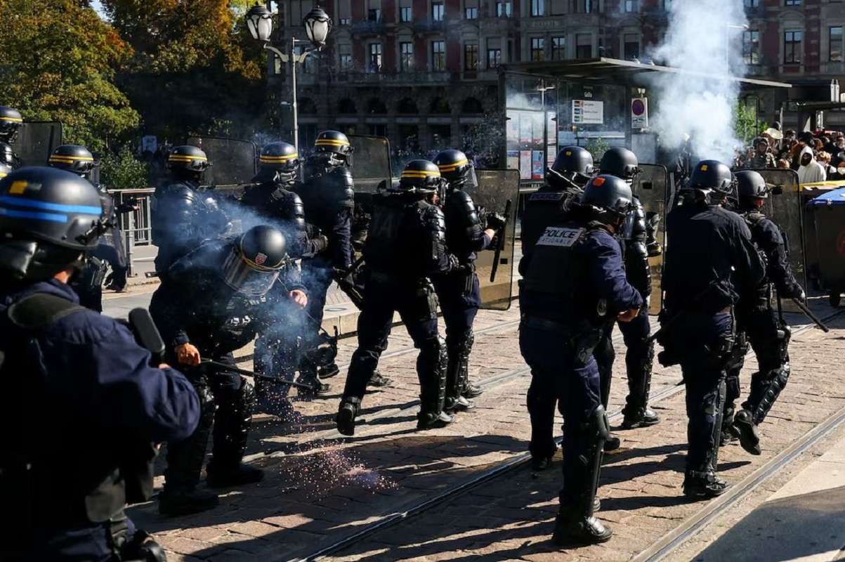 Police stand in position amid clashes with protesters during a demonstration by French high school and university students in Strasbourg as part of a nationwide day of protests and blockades, voicing anger over overcrowded classrooms, teacher shortages and dilapidated school buildings, which students blame on years of underinvestment, France, October 6, 2026. REUTERS/Kai Pfaffenbach
