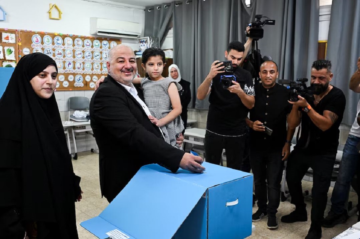 Ο Μανσούρ Αμπάς, επικεφαλής του κόμματος Ραάμ και υποψήφιος στις ισραηλινές εκλογές, κρατά την κόρη του στην αγκαλιά του ενώ ψηφίζει σε εκλογικό τμήμα στην πόλη Μαγκάρ, στις 27 Οκτωβρίου 2026. Φωτογραφία: Rami Shlush / Reuters.