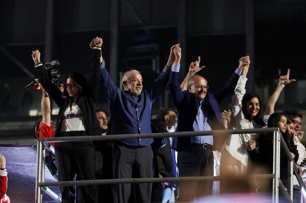Ο Λουίς Ινάσιο Λούλα ντα Σίλβα υψώνει τα χέρια μαζί με τη σύζυγό του, Ροζάνζελα «Ζάνζα» ντα Σίλβα, και τον αντιπρόεδρο Ζεράλντο Αλκμίν, κατά τη διάρκεια των πανηγυρισμών για τη νίκη του στον δεύτερο γύρο των προεδρικών εκλογών, στο Σάο Πάολο της Βραζιλίας, στις 26 Οκτωβρίου 2026. Φωτογραφία: Reuters / Amanda Perobelli