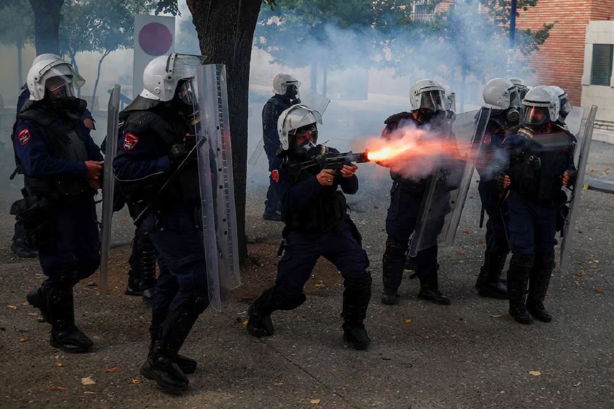 Αστυνομικός εκτοξεύει δακρυγόνα κατά τη διάρκεια συγκρούσεων με διαδηλωτές στα Τίρανα της Αλβανίας, την Πέμπτη (15/10), εν μέσω των αντικυβερνητικών φοιτητικών κινητοποιήσεων. (Φωτογραφία: REUTERS/Florion Goga)