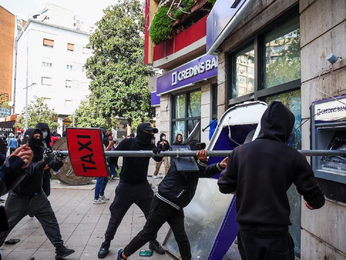 Διαδηλωτές καταστρέφουν μηχάνημα αυτόματης ανάληψης μετρητών (ΑΤΜ) κατά τη διάρκεια συγκρούσεων με την αστυνομία στα Τίρανα της Αλβανίας, την Πέμπτη (15/10). (Φωτογραφία: REUTERS/Florion Goga)