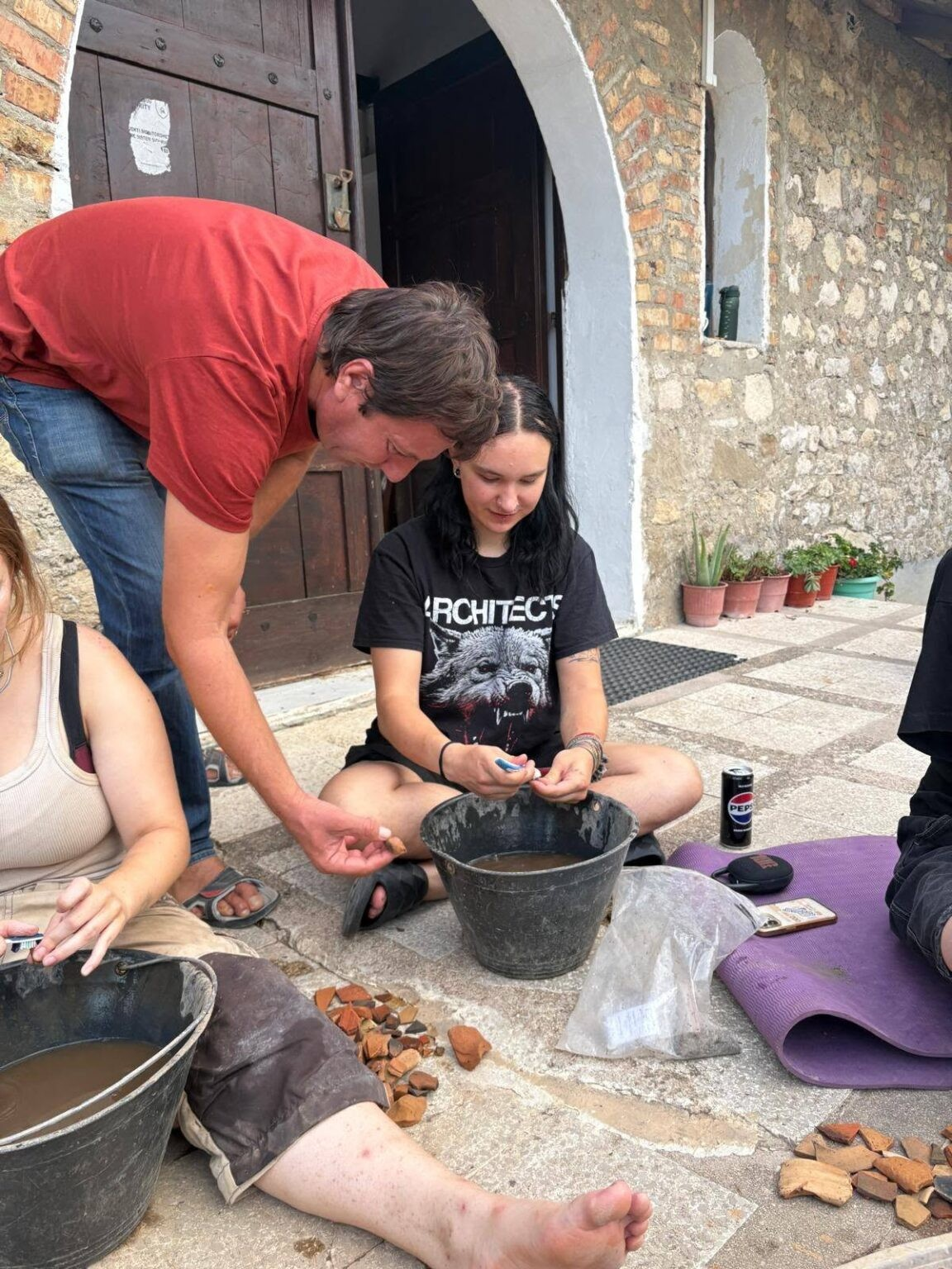Μέλη της αρχαιολογικής ομάδας εξετάζουν και καθαρίζουν θραύσματα κεραμικής που εντοπίστηκαν κατά τη διάρκεια των ανασκαφών του 2026 στον αρχαίο ελληνικό ναό του Στύλλα στην Αλβανία. Φωτογραφία: Ινστιτούτο Αρχαιολογίας, Αλβανία