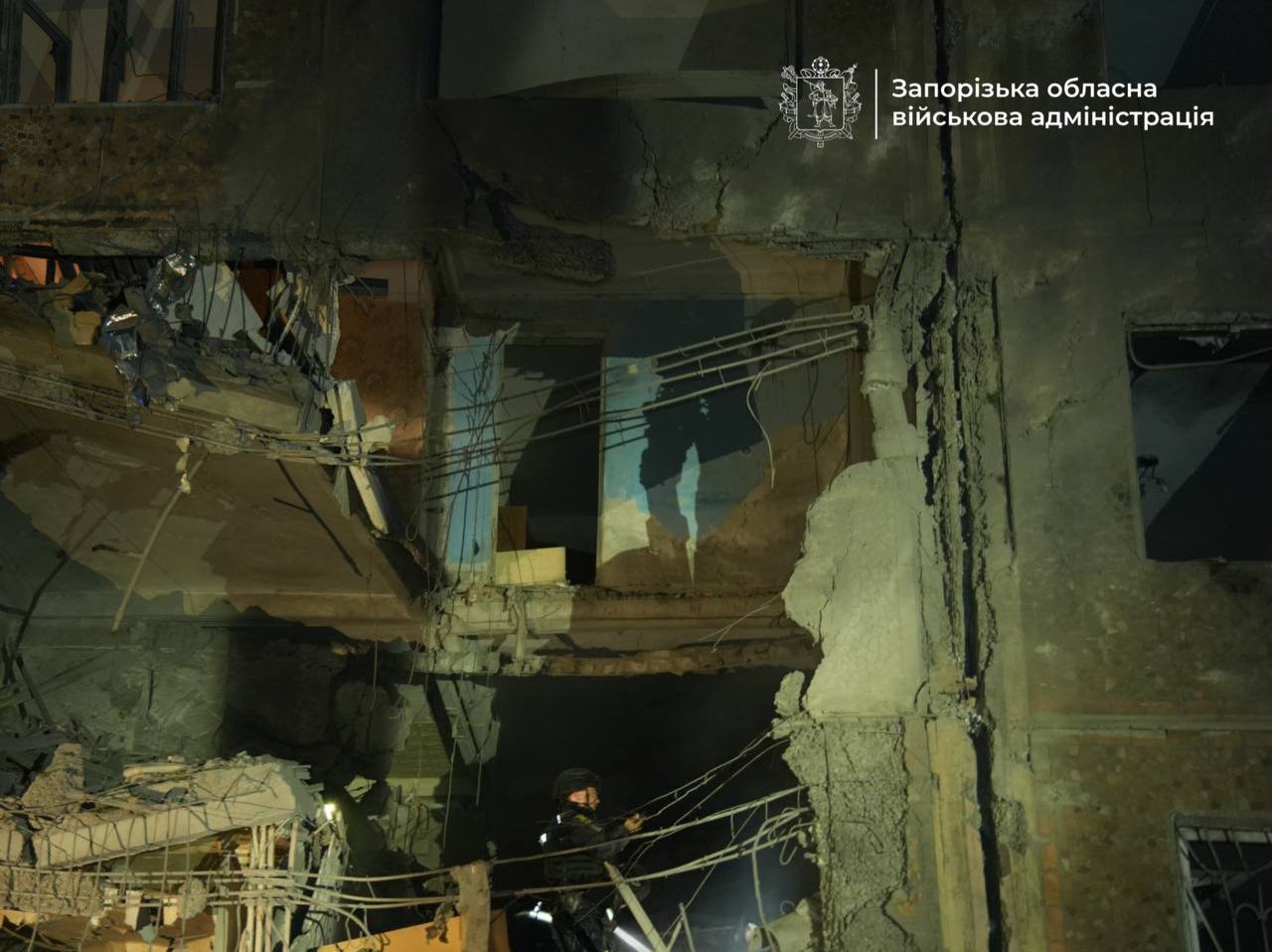 Διασώστης επιχειρεί ανάμεσα στα συντρίμμια πολυκατοικίας που επλήγη από ρωσική αεροπορική επίθεση στη Ζαπορίζια. Πηγή: Περιφερειακή Στρατιωτική Διοίκηση Ζαπορίζια.
